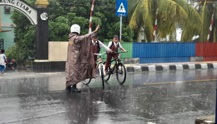 Hujan Tak Halangi Polsek Gerung Atur Lalu Lintas Sekolah