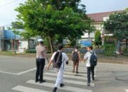 Personel Sat Lantas Polres Bima Kota Bantu Anak Sekolah Menyeberang Jalan