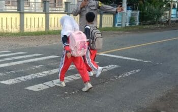 Wujud Polisi Humanis, Brigadir Wawan Satria Atur Lalu Lintas Saat Anak Sekolah di Desa Goa