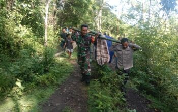 Bhabinkamtibmas dan Warga Marente Tandu Pasien Melewati Akses Jalan Rusak